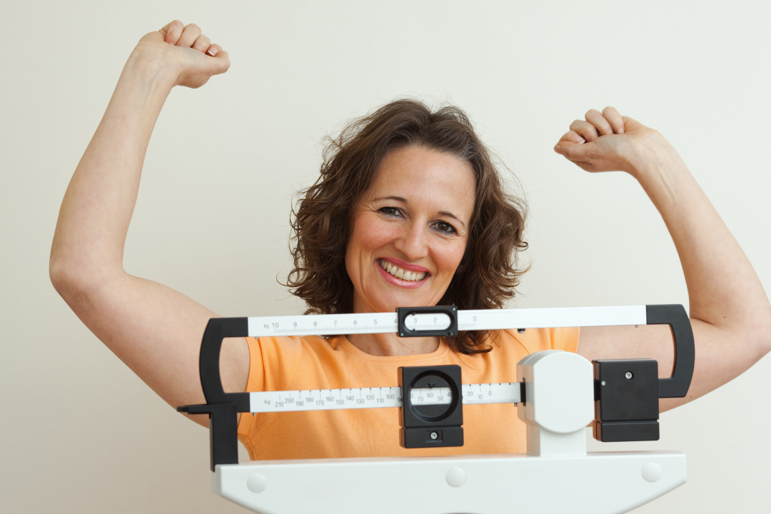 Smiling woman celebrating her progress with medical weight loss.