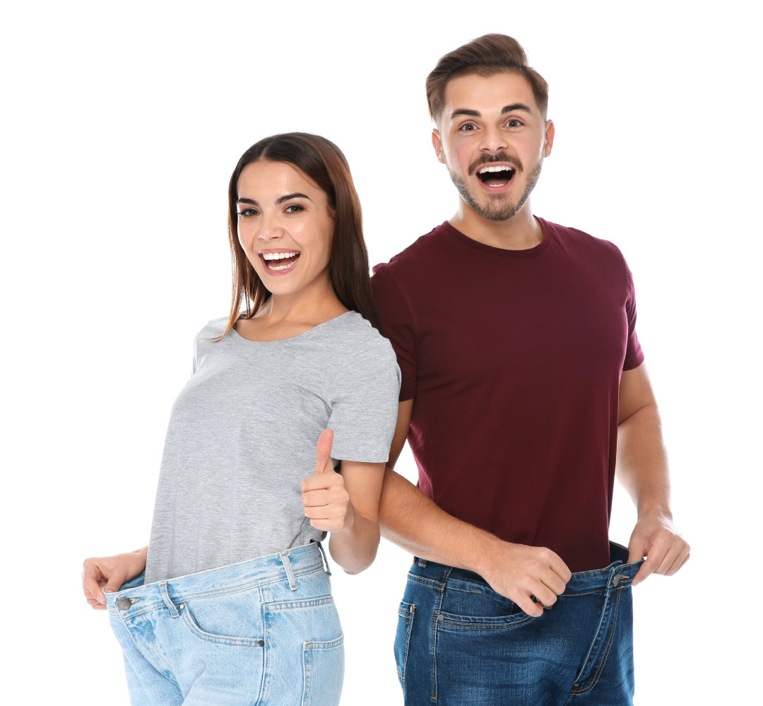 A happy couple shows off loose-fitting pants after successful weight loss with Bioidentical Hormone Replacement Therapy.