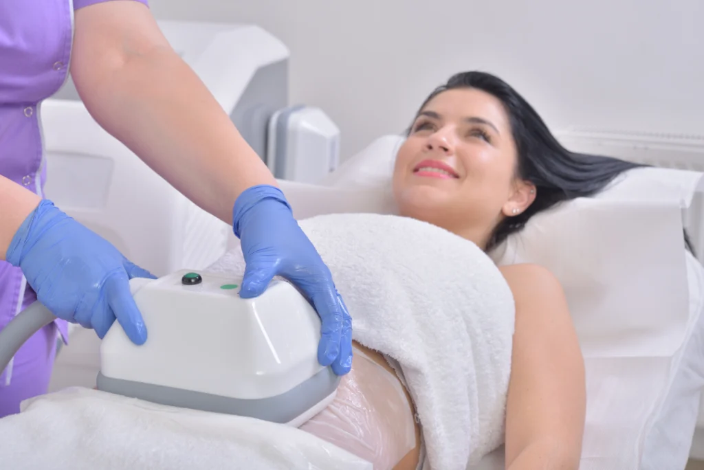 A patient receiving a CoolSculpting treatment on the abdomen, performed by a professional using the cooling device.