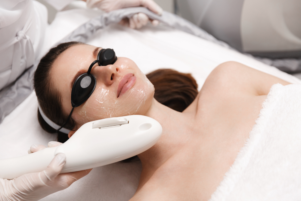 Woman undergoing a BBL session with eye protection and facial gel.