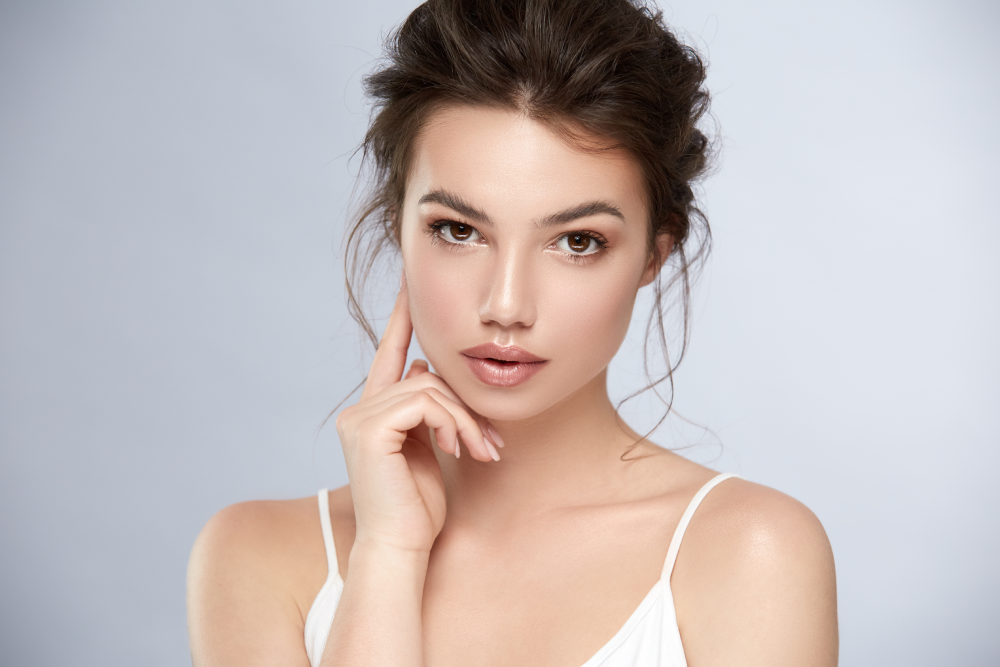 Woman with flawless skin after BBL treatment posing confidently.